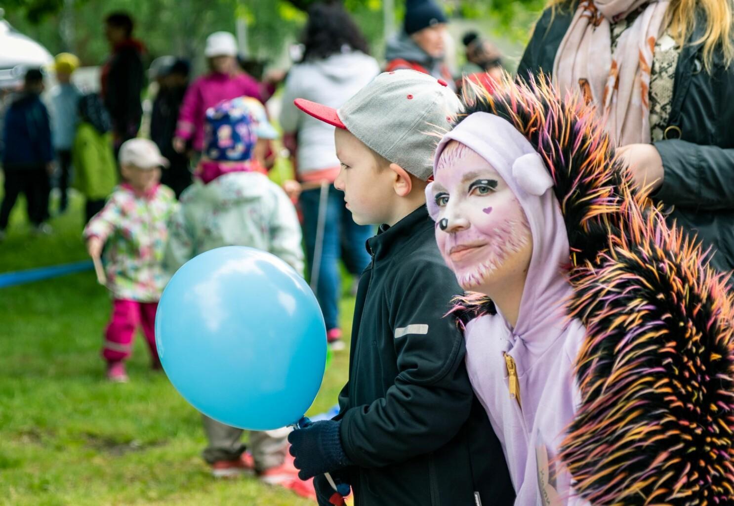 Kuva lastentapahtumasta, jossa haastateltava  on pukeutunut naamiaisasuun, vierellään lapsi sinisen ilmapallon kanssa